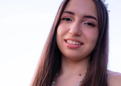 Smiling young woman with long hair against a bright sky